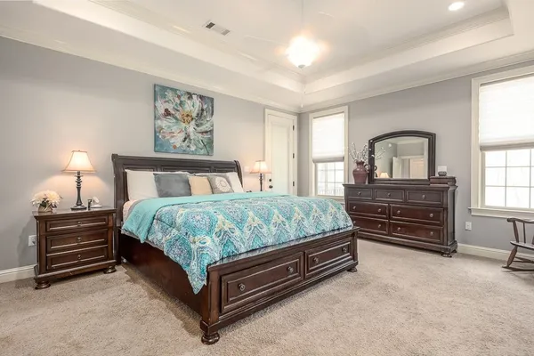 a spacious bedroom with a bed and a chandelier