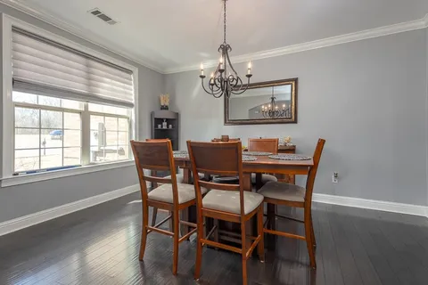 a dining room with furniture a chandelier and wooden floor