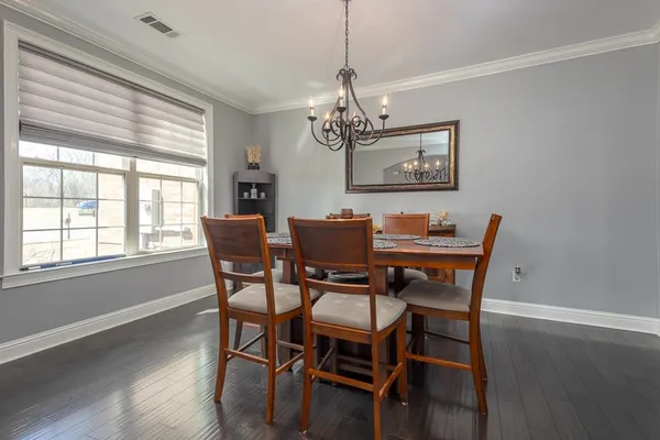 a dining room with furniture a chandelier and wooden floor