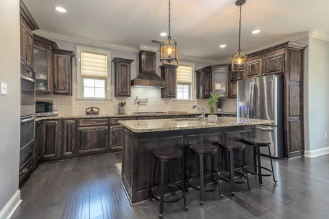a kitchen with granite countertop a sink appliances a counter space and a window