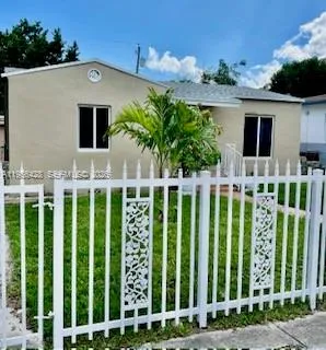 a front view of white house with a yard