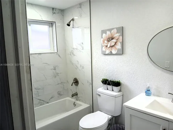 a white toilet sitting next to a bath tub shower