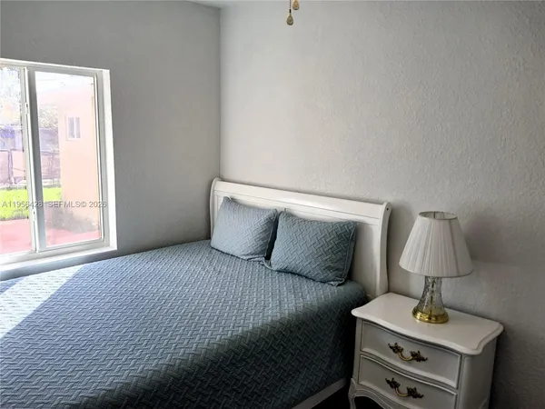 a bedroom with a bed and a lamp