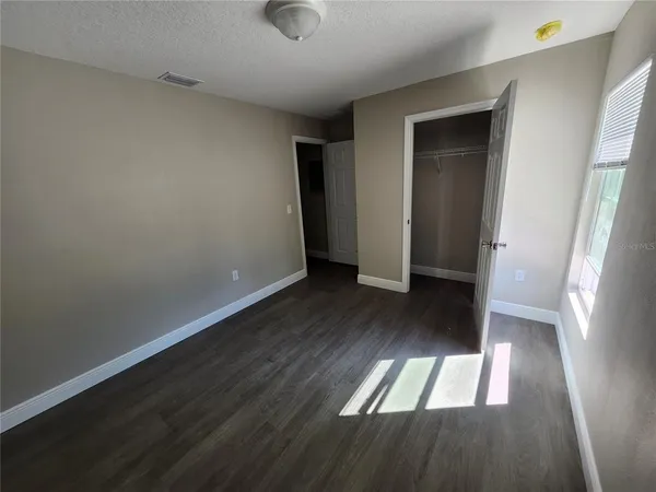 an empty room with wooden floor and entrance