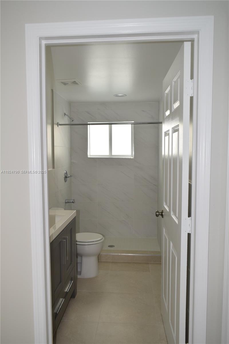 435 Southwest 78th Court Miami, FL 33144 - Photo 17 of 19 a bathroom with a granite countertop toilet a sink and shower