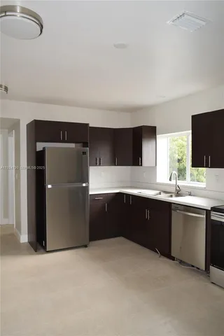 a large kitchen with granite countertop a sink and cabinets