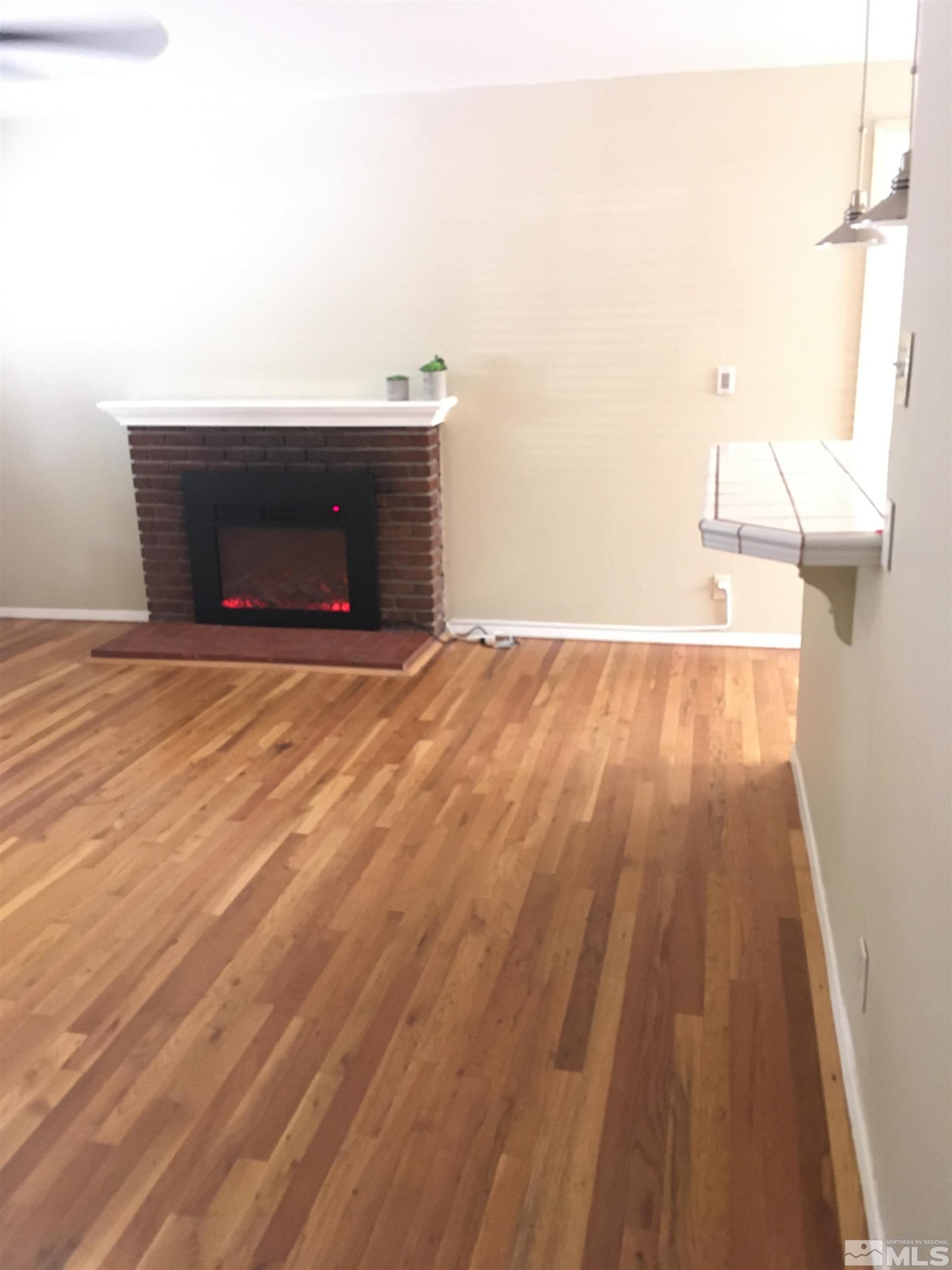 770 Ruby Avenue Reno, NV 89503 - Photo 3 of 18 a view of empty room with wooden floor and fireplace