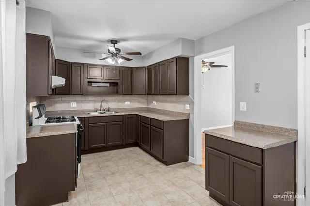 a kitchen with kitchen island granite countertop a sink cabinets and stainless steel appliances