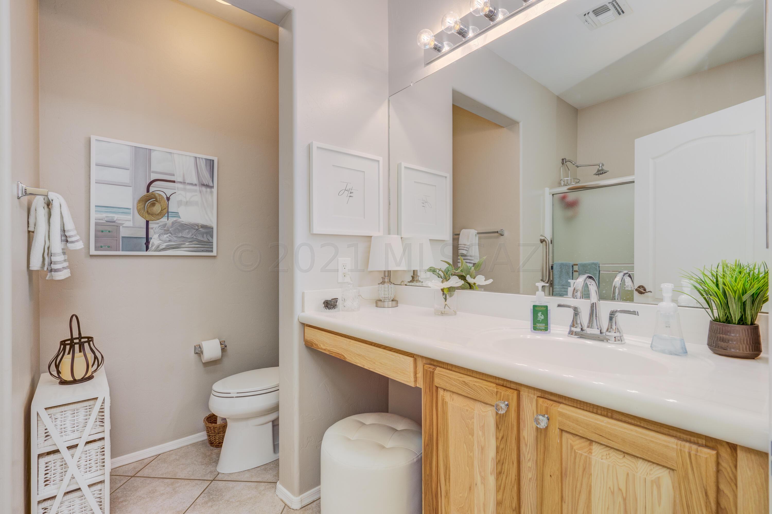 3639 East Northern Dancer Road Tucson, AZ 85739 - Photo 30 of 48 a bathroom with a granite countertop sink mirror and toilet