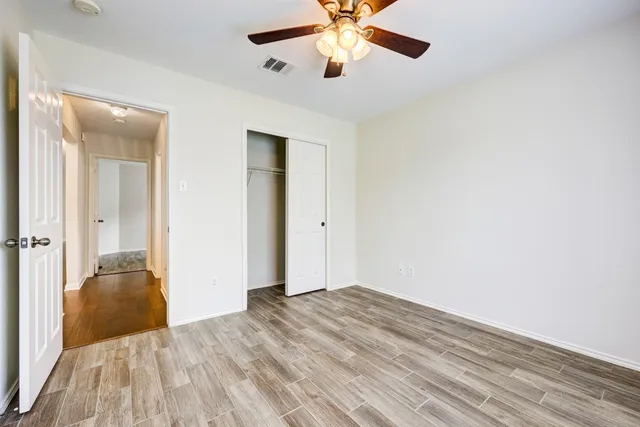 a view of empty room with wooden floor