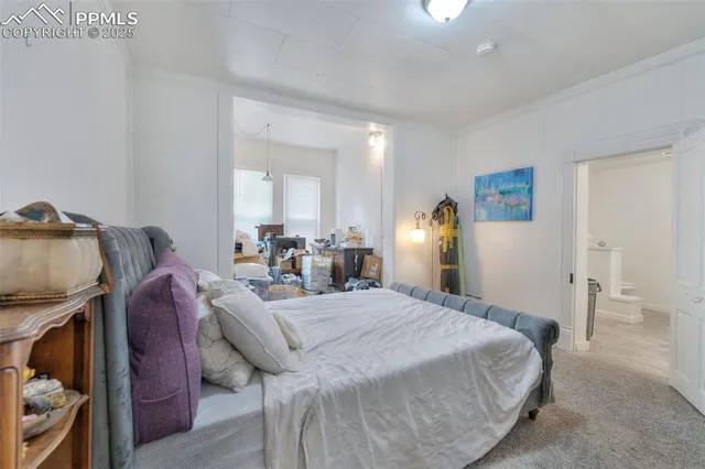 a bedroom with a bed and painting on the wall