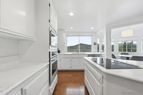 a kitchen with granite countertop a sink and white cabinets