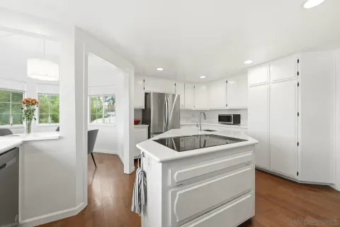 a kitchen with a refrigerator sink and cabinets
