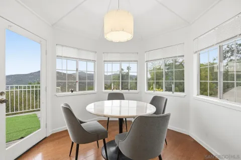 a dining room with furniture a chandelier and wooden floor