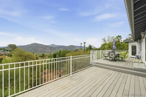 a view of a balcony with wooden floor and iron fence
