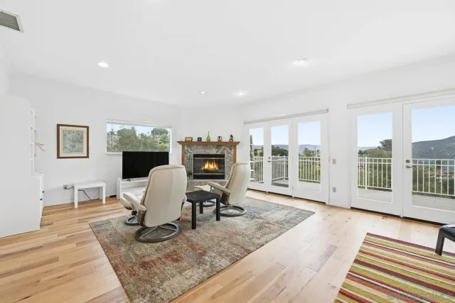 a living room with furniture a rug wooden floor and windows