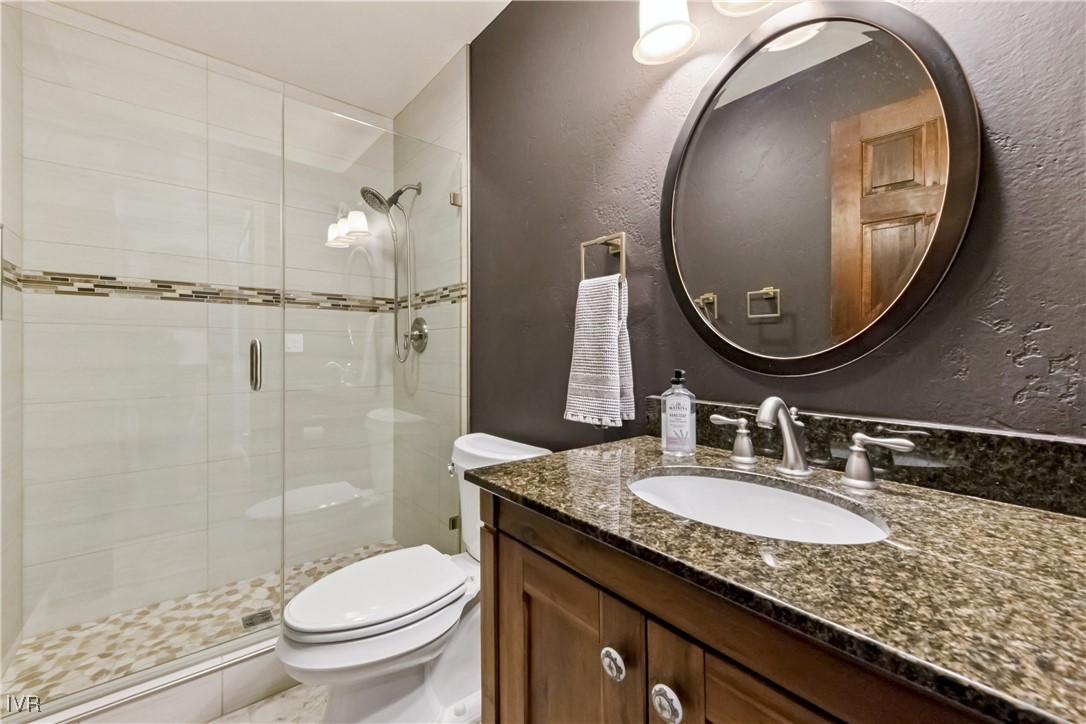 771 Randall Avenue Incline Village, NV 89451 - Photo 32 of 44 a bathroom with a granite countertop toilet a sink and a mirror