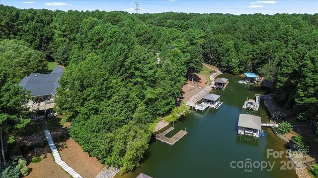 an aerial view of residential houses with outdoor space and trees all around