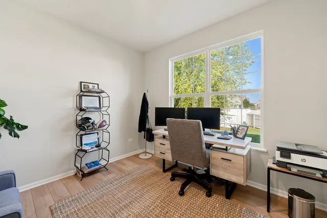 a view of a workspace with furniture and a window