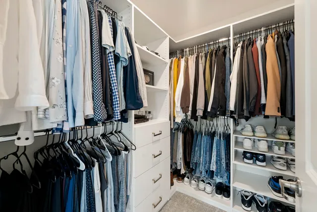 a view of walk in closet with clothes and shoes