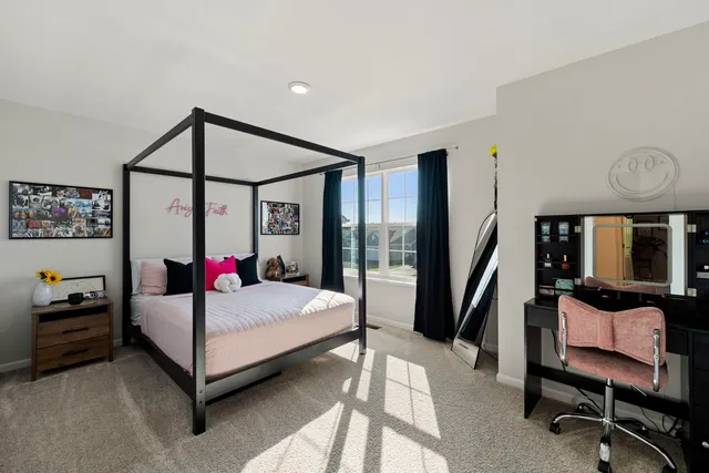 a bedroom with a bed a couch and a large window