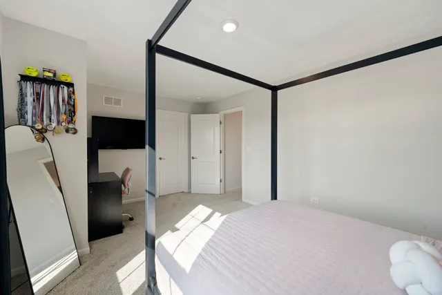 a bedroom with a bed closet and flat tv screen