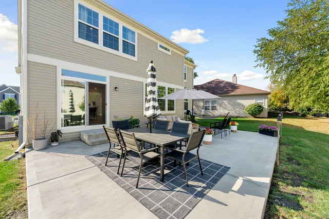 a view of a patio with a table and chairs under an umbrella