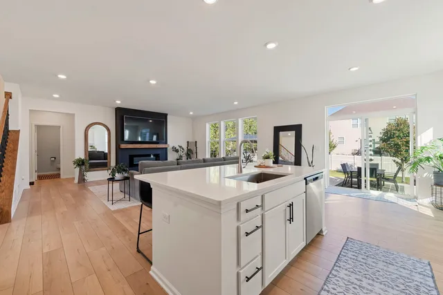 a large white kitchen with a large window and stainless steel appliances