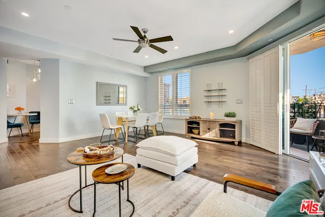 a balcony with couple of flower plants and wooden fence