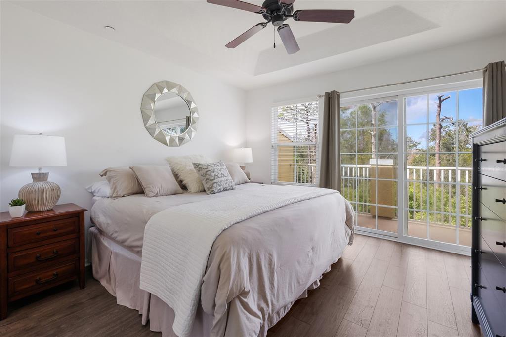 8907 White Sage Loop Lakewood Ranch, FL 34202 - Photo 17 of 33 a bedroom with a large bed and a chandelier