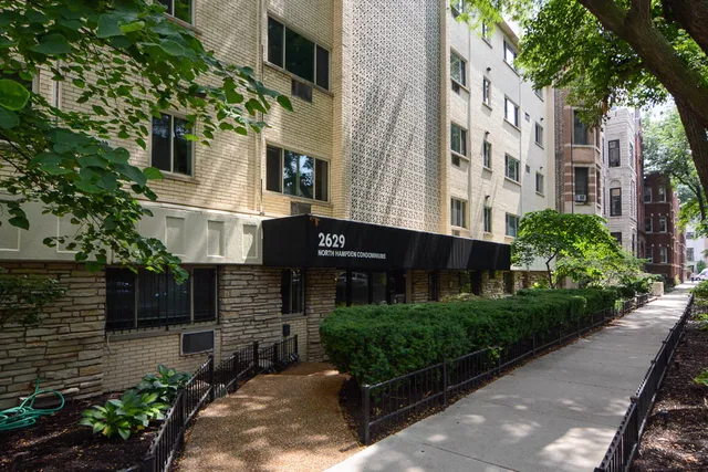 a front view of a multi story building with yard