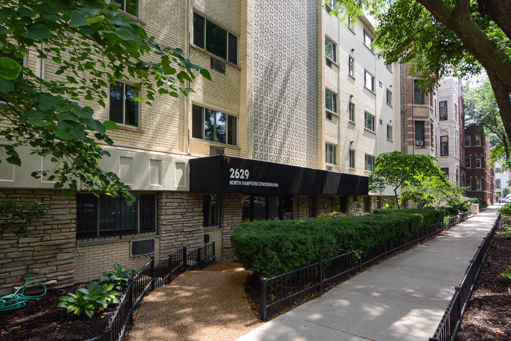 a front view of a multi story building with yard