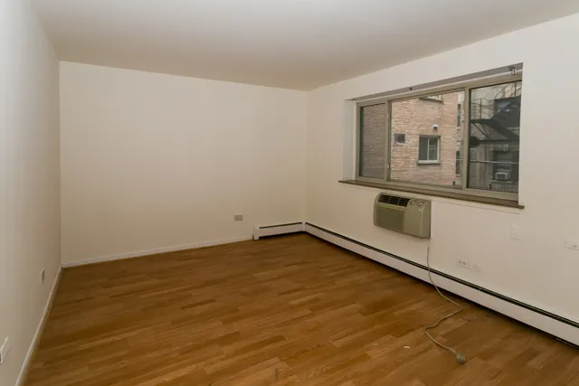 a room with a wooden floor and windows