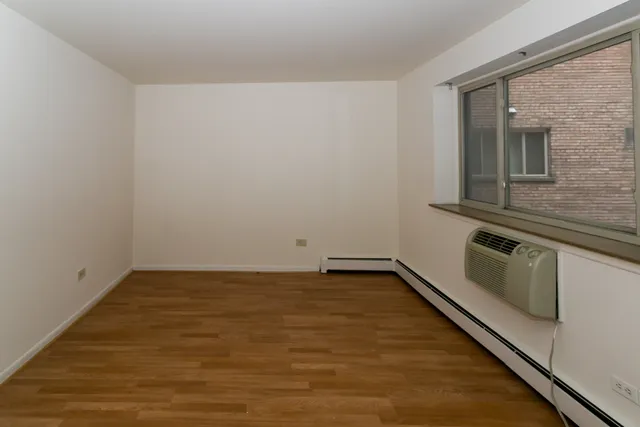 a view of a room with an empty space and wooden floor