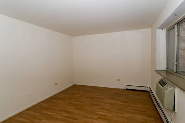 a view of a room with wooden floor and a window
