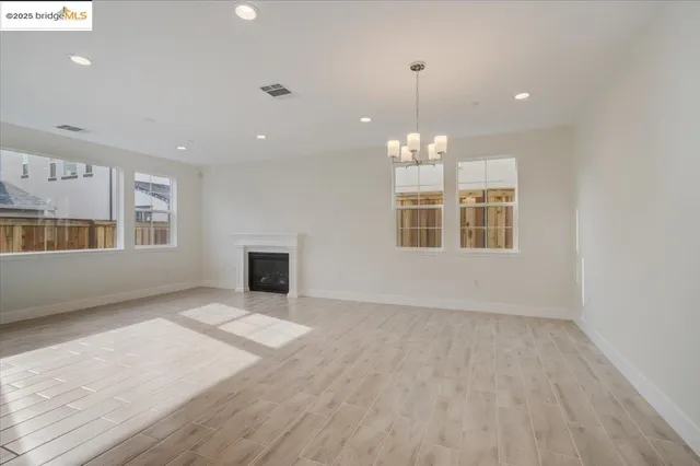 an empty room with chandelier fan