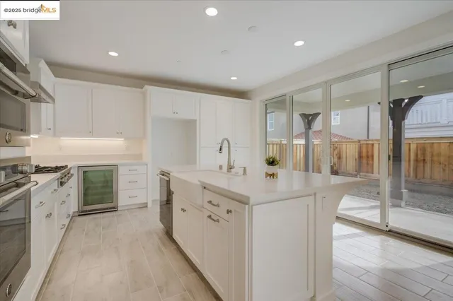 a kitchen with kitchen island white cabinets and stainless steel appliances
