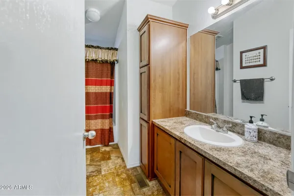 a bathroom with a granite countertop sink and a mirror