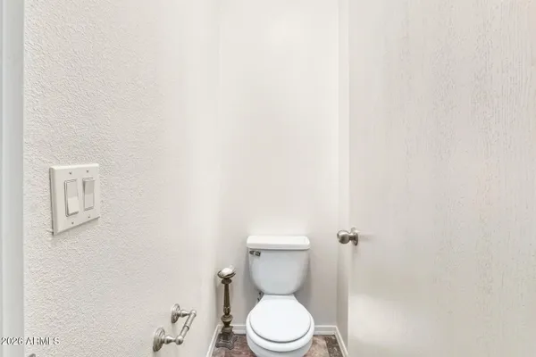 a white toilet sitting next to a white wall