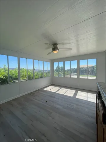 a view of a livingroom with wooden floor and furniture