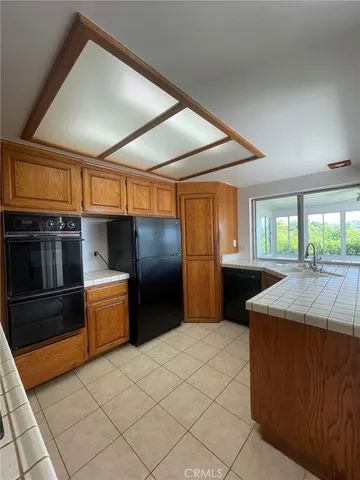 a kitchen with stainless steel appliances granite countertop a sink and a refrigerator