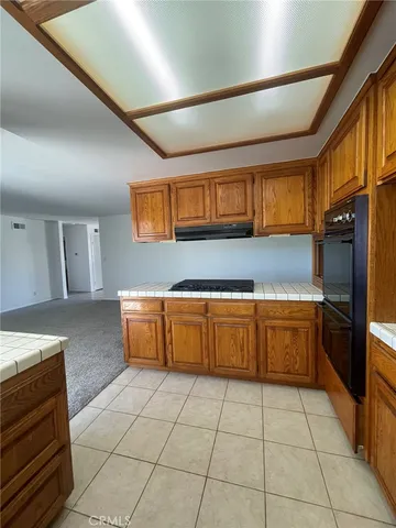 a kitchen with granite countertop a stove a sink and a refrigerator