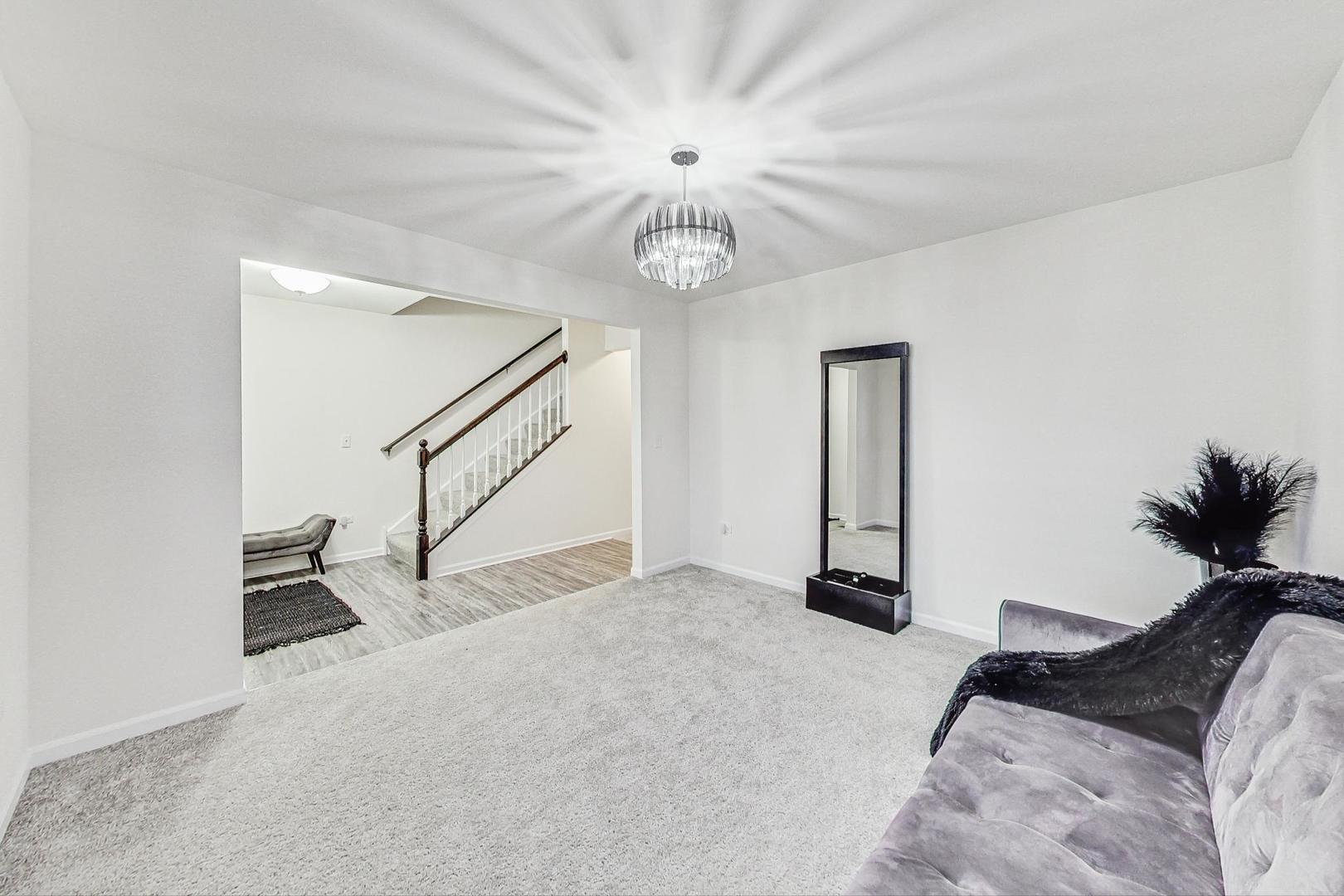 1014 Sharp Drive Plano, IL 60545 - Photo 19 of 52 a bedroom with a bed and a chandelier