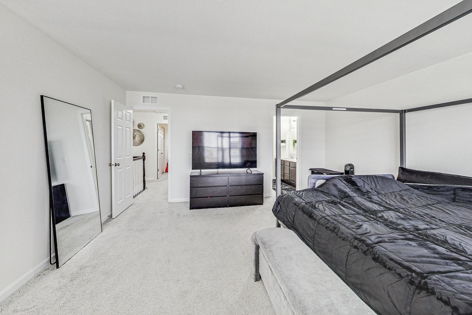 1014 Sharp Drive Plano, IL 60545 - Photo 24 of 52 a large bedroom with a bed and a flat screen tv