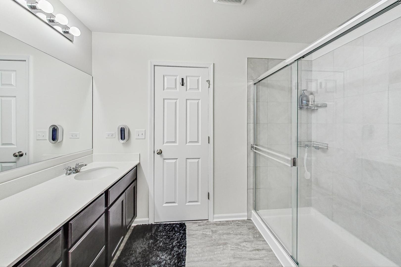 1014 Sharp Drive Plano, IL 60545 - Photo 28 of 52 a bathroom with a double vanity sink and mirror