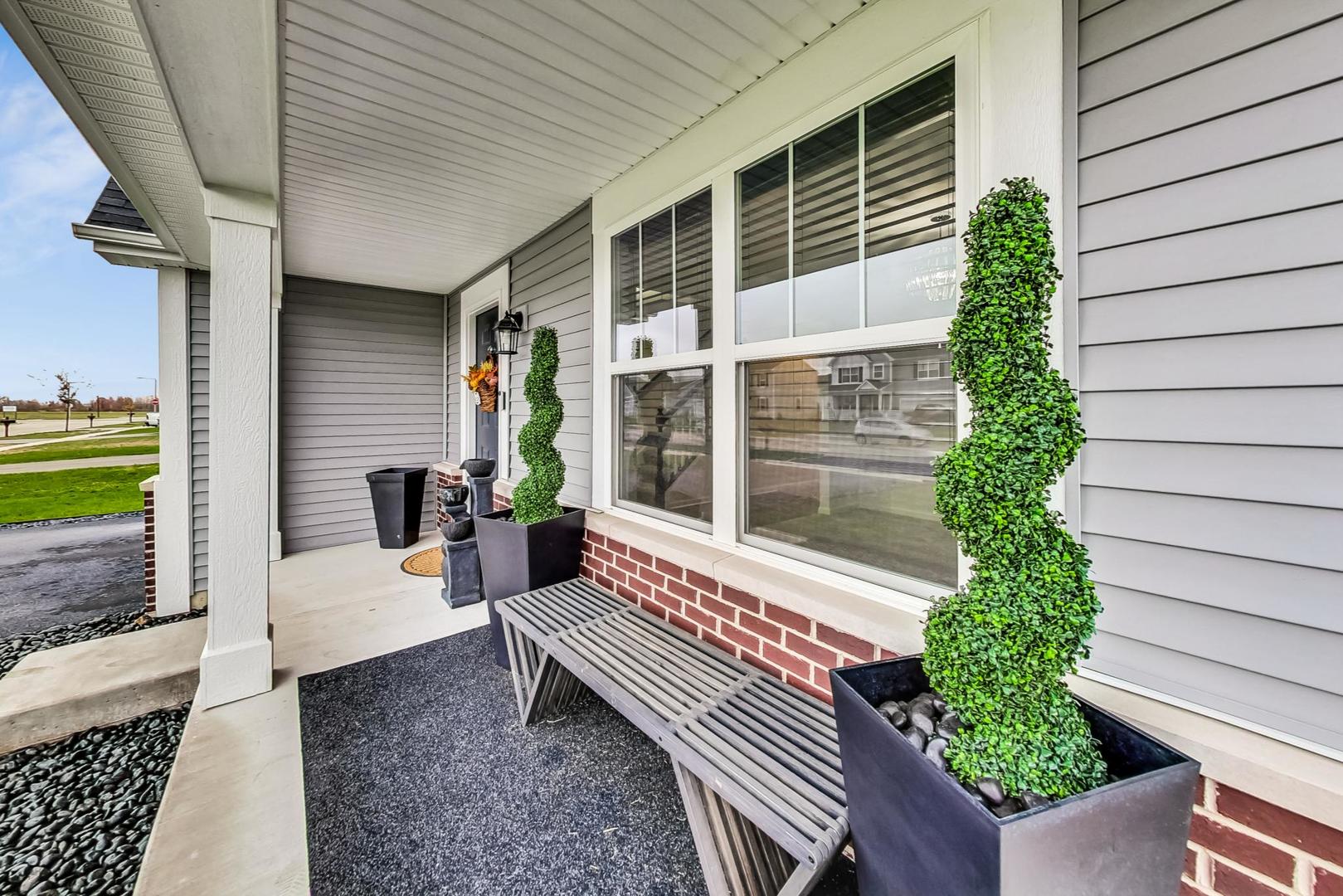 1014 Sharp Drive Plano, IL 60545 - Photo 5 of 52 a porch with a bench next to a yard