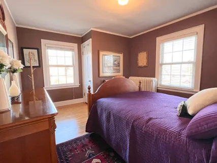 a bedroom with a bed and a large window