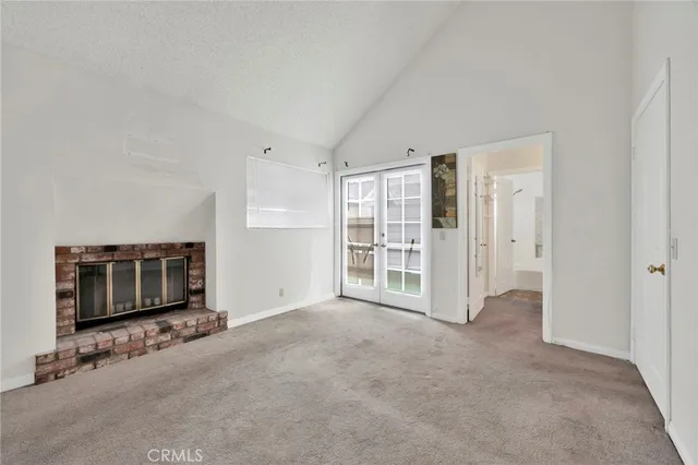 a view of an empty room with a fireplace and a window