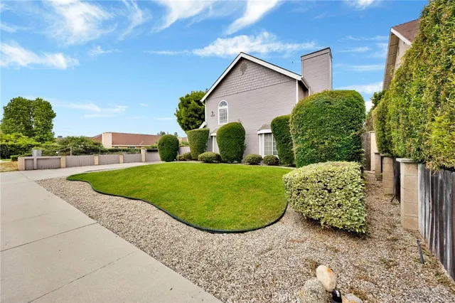 a view of a house with a yard and potted plants
