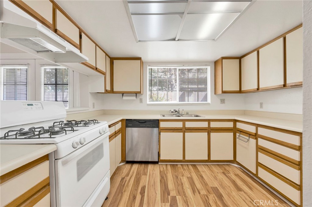 1835 South Alta Vista Avenue, Unit D Monrovia, CA 91016 - Photo 7 of 20 a kitchen with stainless steel appliances granite countertop a stove a sink dishwasher and white cabinets with wooden floor